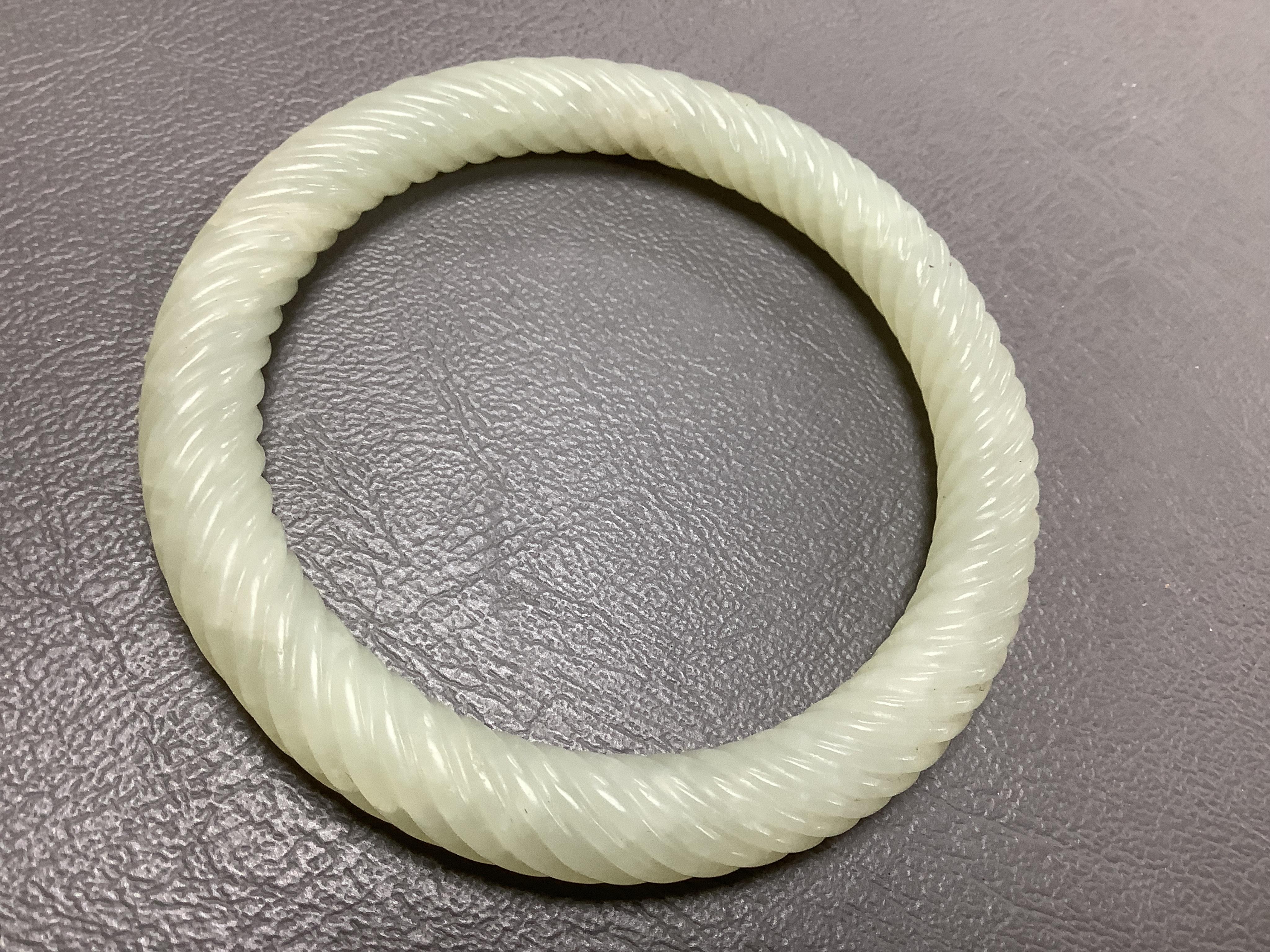 A Chinese pale celadon jade rope twist carved bangle, 8cm diameter